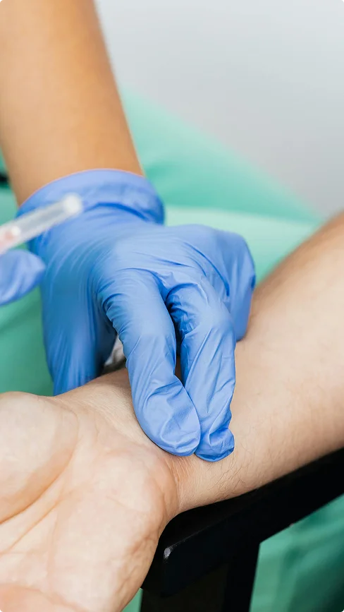 A clinician preparing a patient's arm for a blood draw