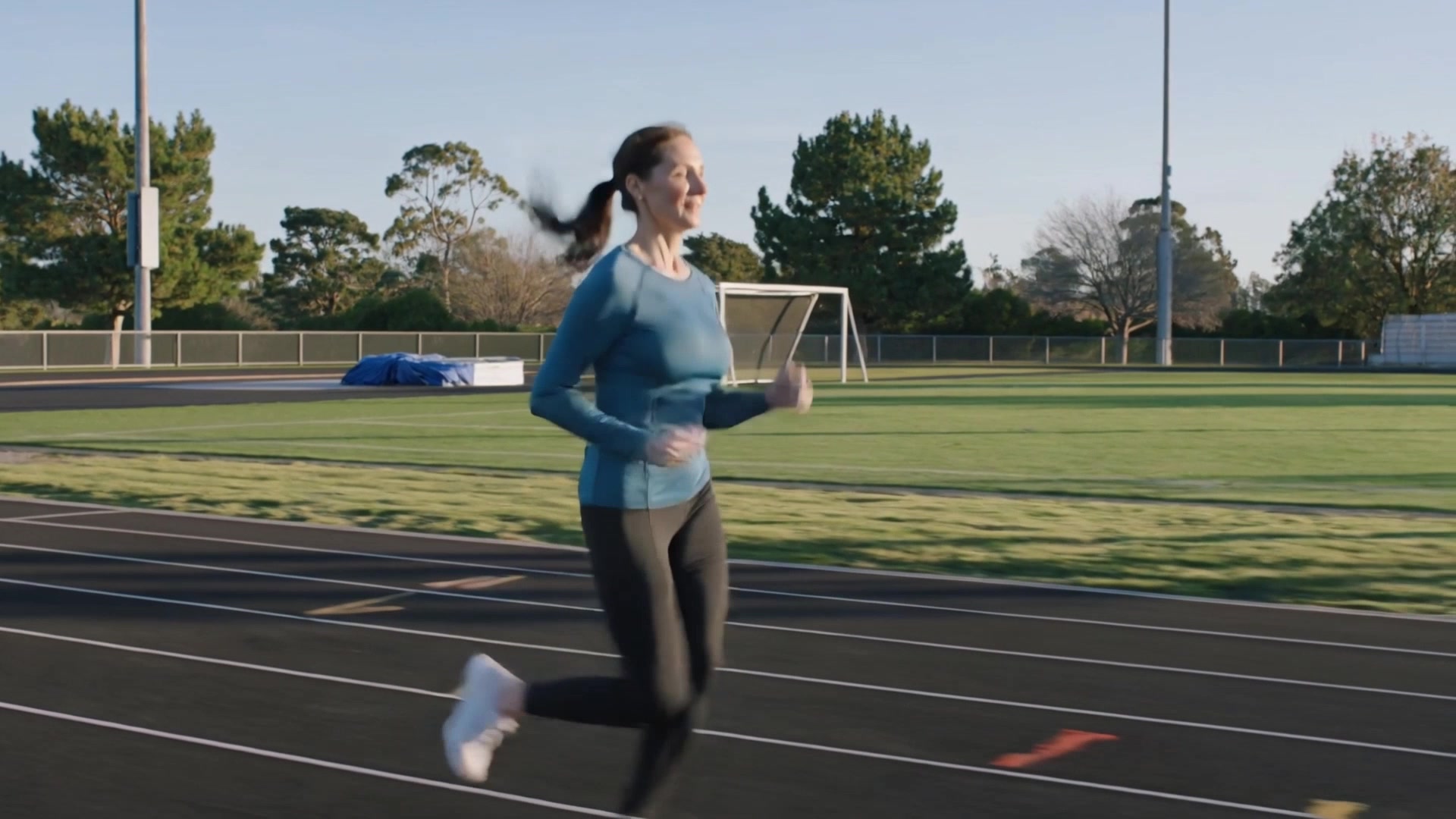AI-generated lifestyle scene of a midlife woman running on an outdoor track